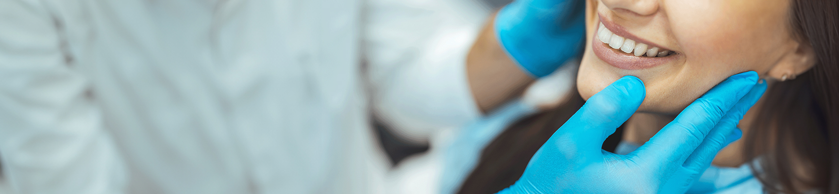 Orthodontist examing the smile of a smiling young adult patient