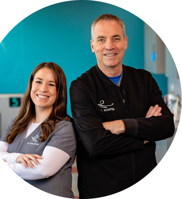 Doctor's Michael Koufos and Emily Koufos-Radford standing back to back and smiling.