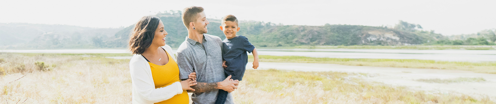 smiling family standing in field